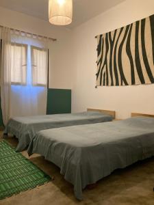 2 camas en una habitación con un cuadro en la pared en Villa Soforal, en Cap Skirring