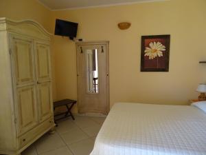 1 dormitorio con 1 cama y TV en la pared en Sole del Mediterraneo en Otranto