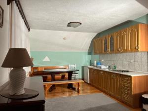 a kitchen with wooden cabinets and a table with a lamp at Apartman Herceg in Kupres