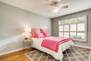 Un dormitorio con una cama con almohadas rosas y una ventana en Exclusive Historical Townhome: serene and cozy en San Antonio