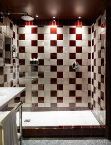 a bathroom with a shower with a checkered wall at Beaverbrook Town House in London