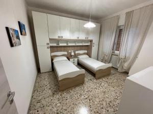 a small bedroom with two beds and a table at 4 PINI in Ancona