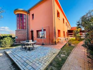 um edifício com uma mesa e cadeiras em frente em Regina Del Mare Holiday Apartments em Tirrenia