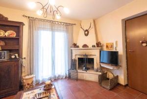 a living room with a fireplace and a television at Maison Bruno in Pescocostanzo