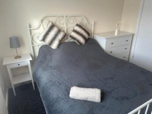 1 dormitorio con 1 cama con manta azul y almohadas en 3 Bedroom House For Corporate Stays in Kettering en Kettering