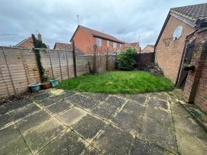 a backyard with a fence and a grass yard at 3 Bedroom House For Corporate Stays in Kettering in Kettering