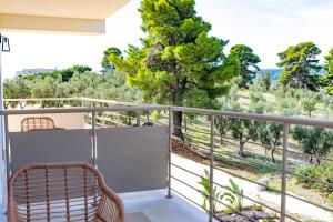 a balcony with a rattan chair and a view of trees at La Posta del Guardiano in Vieste