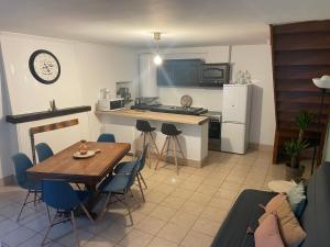 a kitchen and living room with a table and chairs at Cocon douillet en bord de mer in Grandcamp-Maisy