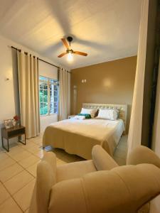 1 dormitorio con 1 cama y 1 sofá en Pousada e Bistrô Estância Monte Horebe en Mulungu