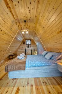 a bed in a room with a wooden ceiling at Vila Deniri in Zlatibor