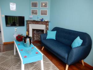 - un salon avec un canapé bleu et une table dans l'établissement Villa des Bains de Mer avec balcon et vue, terrasse 300 m plage, 2 chambres, 3 velos fournis à Mers les Bains Le Treport, à Mers-les-Bains