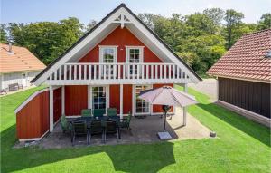 a red barn with chairs and an umbrella at Stunning Home In Grsten With Sauna in Gråsten