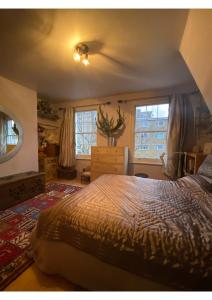 a bedroom with a large bed and two windows at The blue door in London