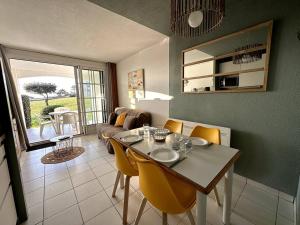 een woonkamer met een tafel en gele stoelen bij Appartement vue Port Bourgenay, emplacement idéal in Talmont
