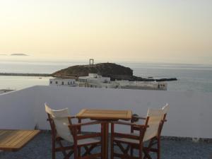 a table and chairs on a balcony with a view of the ocean at Panorama Hotel in Naxos Chora
