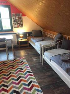 een zolderkamer met 2 bedden en een tapijt bij Gemütliche Wohnung auf dem Ziegenhof in Lemgo