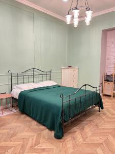 Charming Apartment near Marjanishvili Square في تبليسي: غرفة نوم بسرير وبطانية خضراء