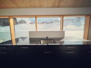 a kitchen with a sink and a window at 3 bedroom condo in front of Obersaxen ski resort in Obersaxen