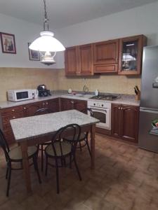 una cucina con tavolo e sedie e frigorifero di Casamarche a Montalto Dora