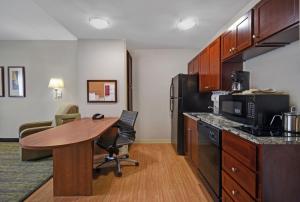 a kitchen with a wooden table and a desk in a room at Candlewood Suites - Mooresville Lake Norman, an IHG Hotel in Mooresville