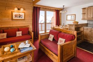 a living room with wooden furniture and a kitchen at Résidence Lagrange Vacances Les Hauts de Comborcière in La Toussuire