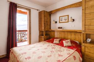 a bedroom with a bed and a large window at Lagrange Vacances Les Hauts de Comborcière in La Toussuire +29 photos