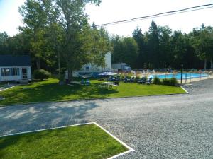 a yard with a swimming pool and a house at Belle Isle Motel in Bar Harbor