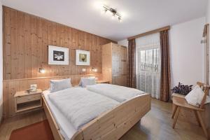 a bedroom with a large bed and a wooden wall at Apartments Schönblick in Mühlbach