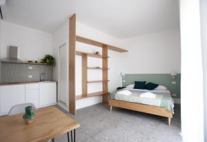 a bedroom with a bed and a table and a kitchen at Casa27 in Terracina