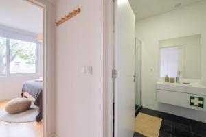 Habitación con baño con lavabo y espejo. en Vila Nova Suite Apt (historic PDL city center) en Ponta Delgada