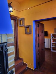 una habitación con una pared azul y amarilla y una puerta en Casa Rural Reyes, en Nuévalos