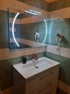a bathroom with a sink and a mirror with lights at Appartamenti Leonardo Airport in Azzano San Paolo
