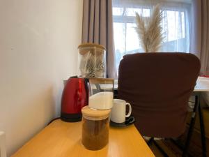 een bureau met een stoel en een tafel met kopjes erop bij Nice Living Serviced Accommodations 4 in Coventry