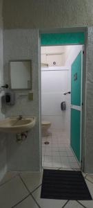a bathroom with a sink and a door to a toilet at Chante in Puerto Escondido
