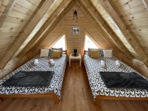 dwa łóżka na poddaszu miniaturowego domku w obiekcie Brvnare MADERA Banja Ždrelo w mieście Ždrelo