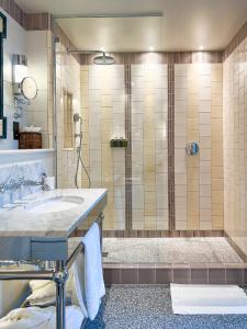 ein Bad mit einer Dusche und einem Waschbecken in der Unterkunft Beaverbrook Town House in London