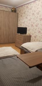 a room with two beds and a tv on the wall at Apartamenty Izera Jaworzno blisko Katowic in Jaworzno