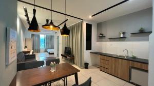 a kitchen and a living room with a table at ITCC Manhattan Suites by PRIME in Penampang
