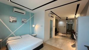 - une chambre avec un lit blanc et un mur bleu dans l'établissement ITCC Manhattan Suites by PRIME, à Penampang