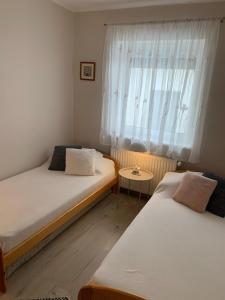 2 camas en una habitación pequeña con ventana en Mátrai Kisház, en Mátraszentimre