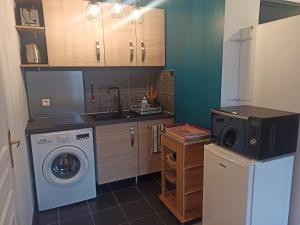 a kitchen with a washing machine and a washer at Studio cosy, Meaux centre, Disney-Paris, proche gare et activités in Meaux