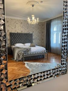 a mirror reflecting a bedroom with a bed in a room at Fancy Flats in Sibiu