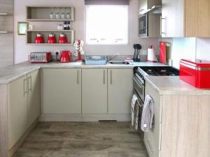 a kitchen with a sink and a stove top oven at Windy Roost Lodge in Tydd Saint Giles