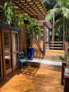 una terraza de madera con una silla y una maceta en Cabana Toca Verde - Conheça a Serra do Rio do Rastro, en Orleans