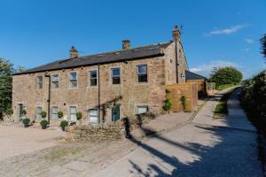 an old brick building with a stone fence in front of it at Luxury 4 Bed Dales Retreat Private Walled Garden All Ensuite Sleeps 8 SuperKing 1 Double 2 King 1 in Embsay