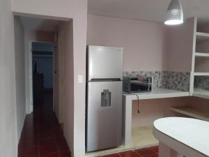 a kitchen with a stainless steel refrigerator and a microwave at Beicoc2 in Cozumel