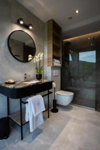 Hotel Beskid BALNEO Medical Resort & SPA في بيفنيتشنا: حمام مع حوض وحوض ومرآة