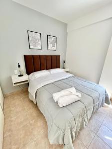 a bedroom with a large bed with two towels on it at Plaza Caviahue Apartment in Neuquén