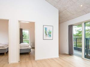 biały pokój z łóżkiem i oknem w obiekcie Holiday home Rømø CXXV w mieście Sønderby