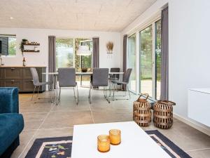 een woonkamer met een tafel en stoelen bij Holiday home Rømø CXXV in Sønderby